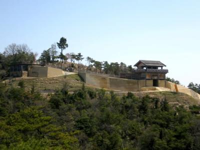 鬼ノ城の復元された西門と城壁の写真