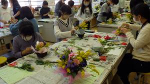 地元の花を使って小学生がフラワーアレンジメントを作成する様子